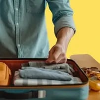 A student packing their suitcase to travel to their university abroad. 